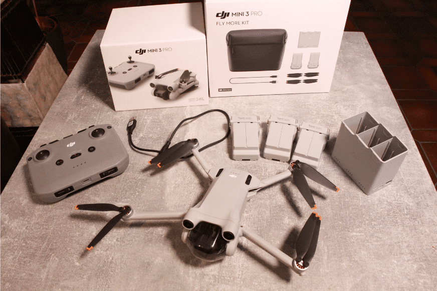 Das DJI Fly More Kit und die DJI Mini 3 Pro liegen auf einem Tisch.